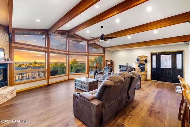 living room with hardwood / wood-style floors, a fireplace, lofted ceiling with beams, and ceiling fan