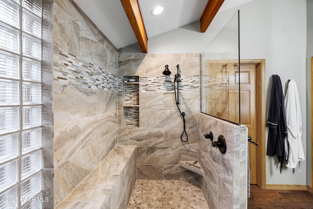 bathroom featuring a tile shower and lofted ceiling with beams