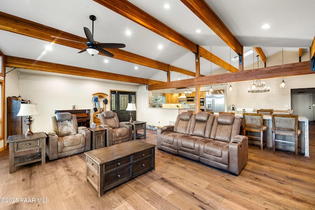 living room featuring ceiling fan with notable chandelier, light hardwood / wood-style flooring, and vaulted ceiling with beams