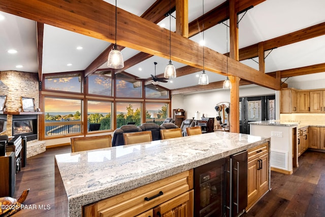 kitchen featuring a center island, beam ceiling, wine cooler, and hanging light fixtures