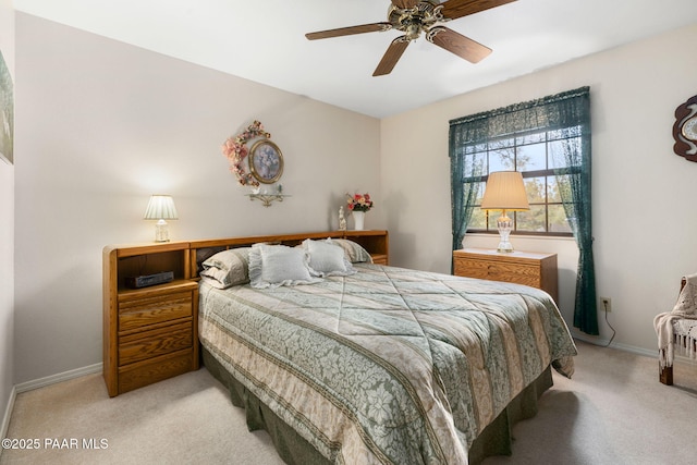 bedroom with light colored carpet, baseboards, and ceiling fan