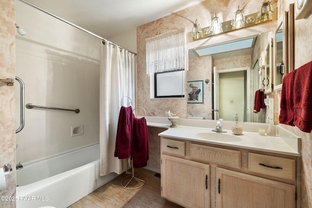 bathroom with shower / bath combo, wood finished floors, and vanity