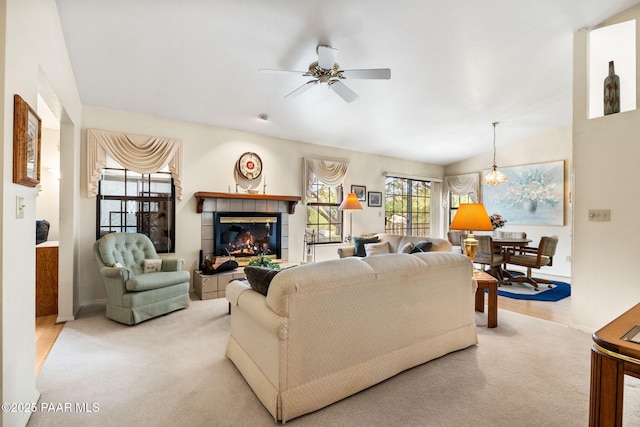 carpeted living room with a ceiling fan, a fireplace, and baseboards