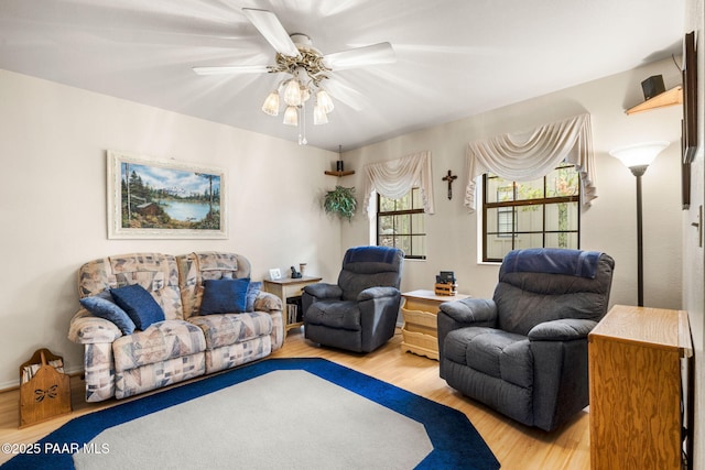 living area with ceiling fan and wood finished floors