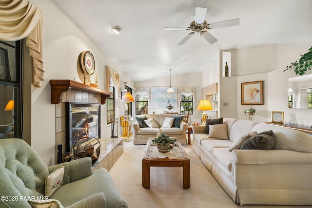 carpeted living room with ceiling fan, a fireplace, and vaulted ceiling