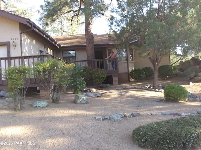 exterior space with stucco siding, a wooden deck, and stairs