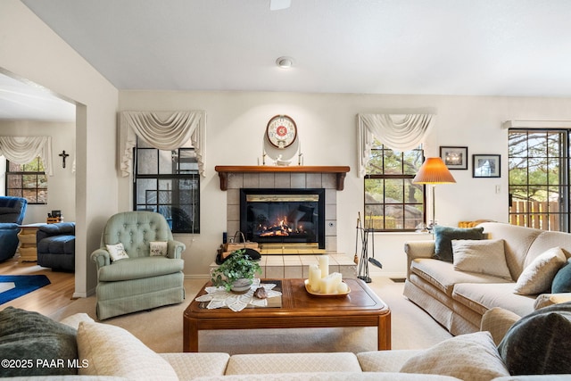 carpeted living area featuring a tile fireplace