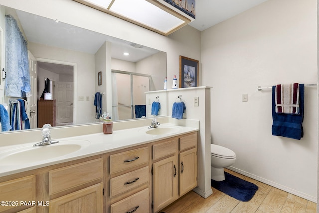 full bath featuring double vanity, a stall shower, wood finished floors, and a sink