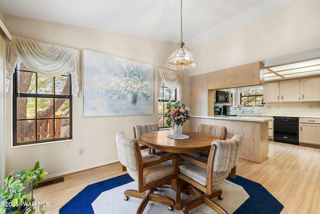 dining room featuring light wood-style floors, visible vents, and baseboards