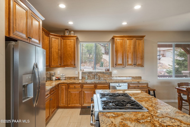 4995 Cactus Pl, Prescott, AZ 86301 - kitchen featuring stainless steel appliances, a sink, recessed lighting, light stone countertops, and brown cabinetry