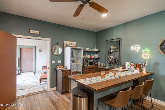 4995 Cactus Pl, Prescott, AZ 86301 - bar featuring light wood-type flooring, ceiling fan, baseboards, and a sink
