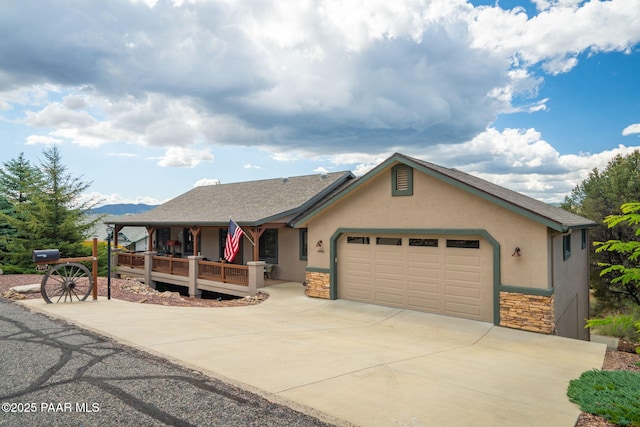 4995 Cactus Pl, Prescott, AZ 86301 - view of front of property with stone siding, a porch, stucco siding, and an attached garage