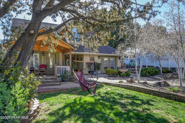 205 S Arizona Ave, Prescott, AZ 86303 - back of property featuring a porch, a shingled roof, stucco siding, and a lawn