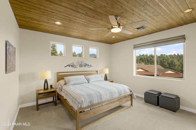 carpeted bedroom with ceiling fan, wooden ceiling, and multiple windows