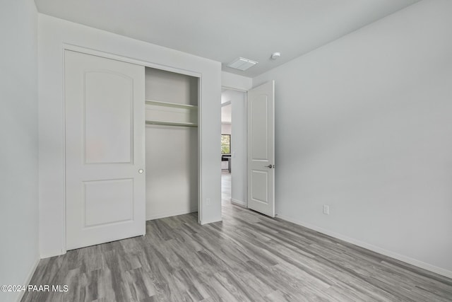 unfurnished bedroom featuring a closet and light hardwood / wood-style floors