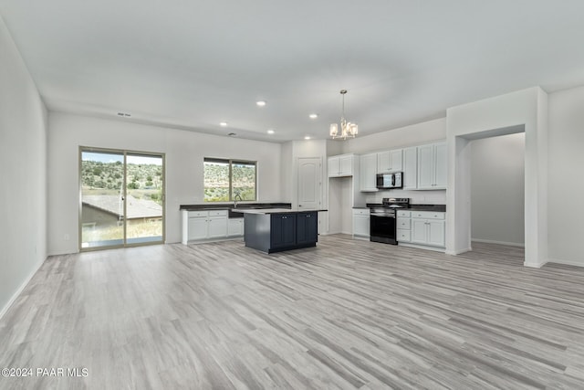 kitchen with white cabinets, decorative light fixtures, a center island, and appliances with stainless steel finishes