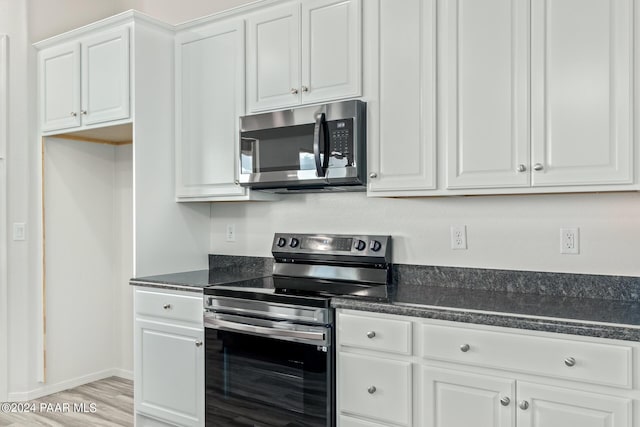 kitchen featuring stainless steel appliances, white cabinetry, and light hardwood / wood-style flooring