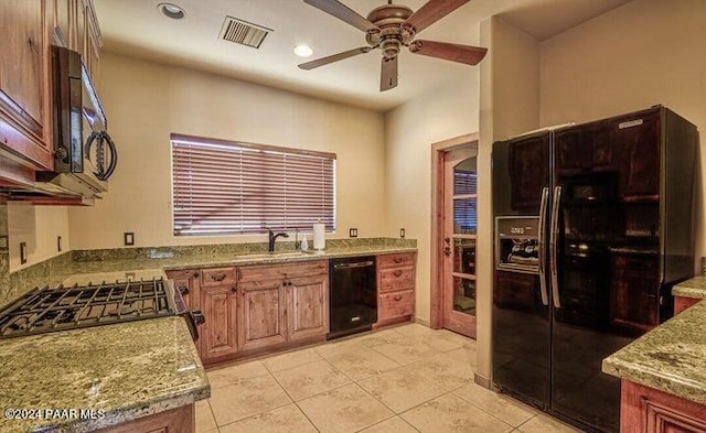 kitchen featuring black appliances, sink, ceiling fan, light stone countertops, and light tile patterned flooring