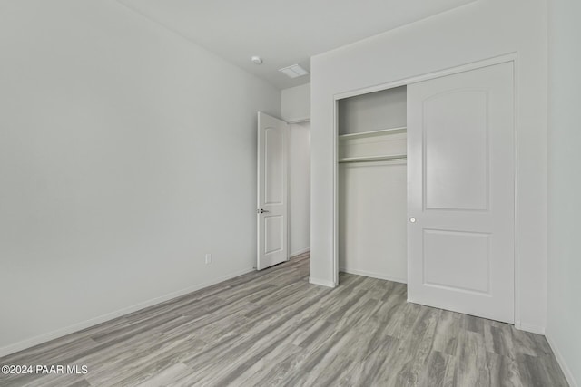 unfurnished bedroom with light hardwood / wood-style floors and a closet