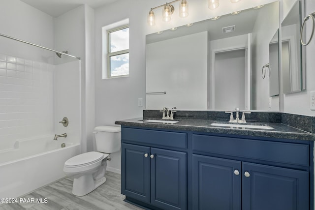 full bathroom featuring toilet, wood-type flooring, vanity, and bathing tub / shower combination