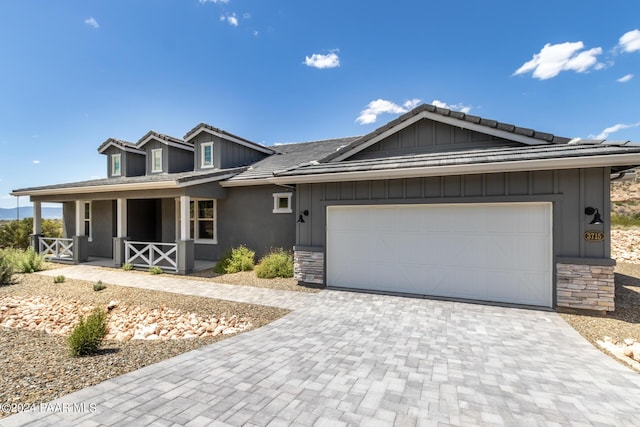 ranch-style home with covered porch and a garage