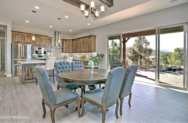 dining area featuring light hardwood / wood-style flooring and an inviting chandelier