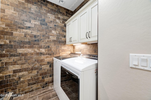 laundry area with cabinets and washing machine and clothes dryer