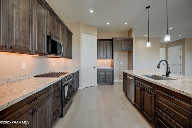1438 W Anne Marie Dr, Chino Valley, AZ 86323 - kitchen with stainless steel appliances, dark brown cabinets, light stone countertops, light wood finished floors, and recessed lighting