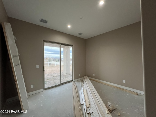 unfurnished bedroom featuring concrete floors and access to outside