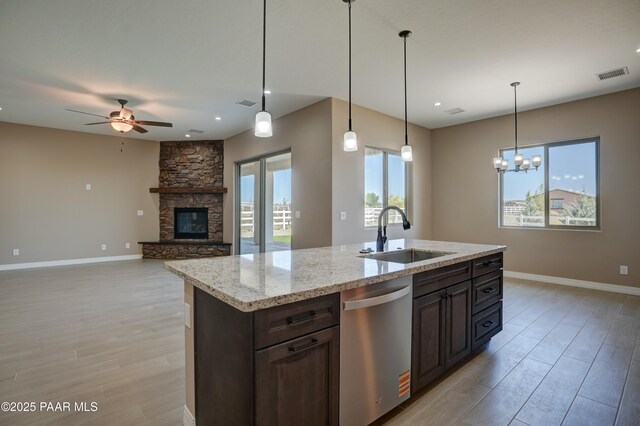 1438 W Anne Marie Dr, Chino Valley, AZ 86323 - kitchen featuring stainless steel dishwasher, light wood-type flooring, a ceiling fan, a fireplace, and dark brown cabinetry