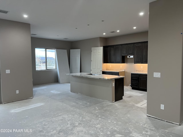 kitchen with light stone countertops and a kitchen island