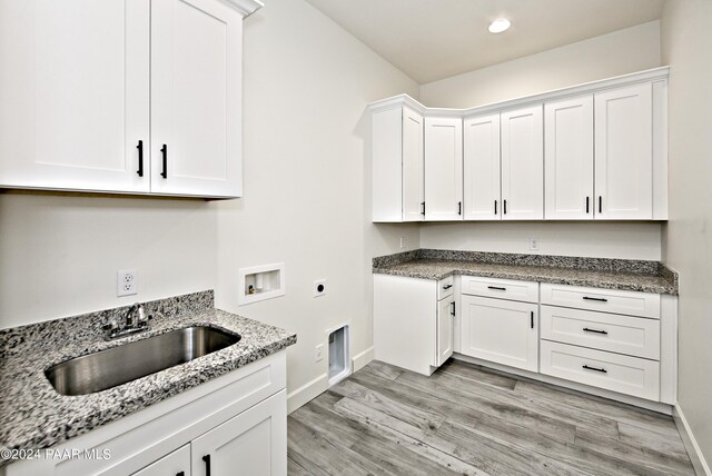 laundry room with a sink, light wood-type flooring, hookup for an electric dryer, cabinet space, and hookup for a washing machine