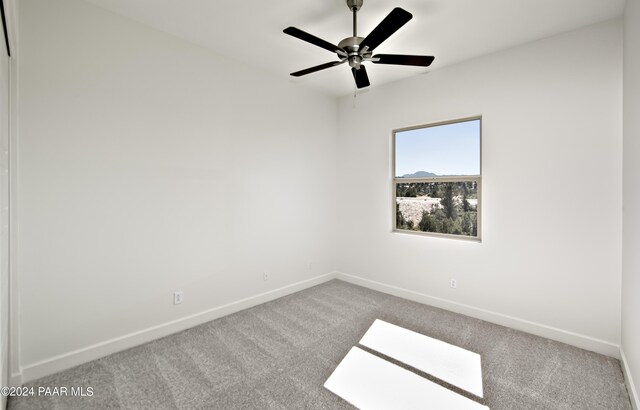 empty room featuring baseboards, carpet flooring, and a ceiling fan