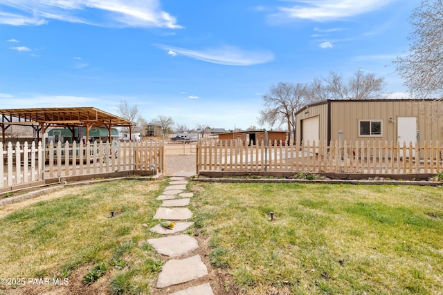 view of yard with a garage, an outdoor structure, and fence