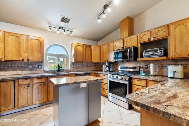 kitchen with visible vents, lofted ceiling, light tile patterned flooring, stainless steel appliances, and a sink