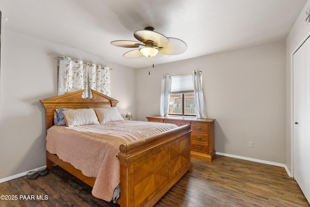 bedroom with dark wood-style floors, a closet, a ceiling fan, and baseboards