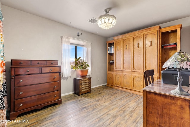 office with visible vents, baseboards, a notable chandelier, and light wood finished floors