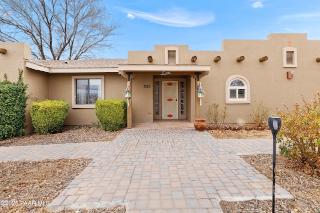 pueblo-style home featuring stucco siding