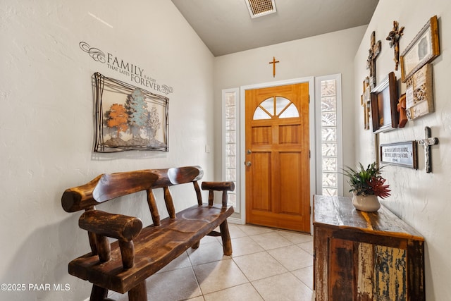 foyer entrance with light tile patterned flooring and visible vents