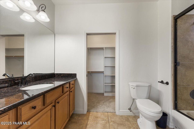 full bathroom featuring tile patterned flooring, vanity, combined bath / shower with glass door, and toilet