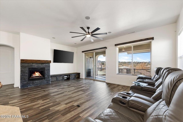 living room with ceiling fan, dark wood-type flooring, and a fireplace