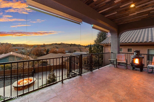 balcony at dusk featuring a fire pit