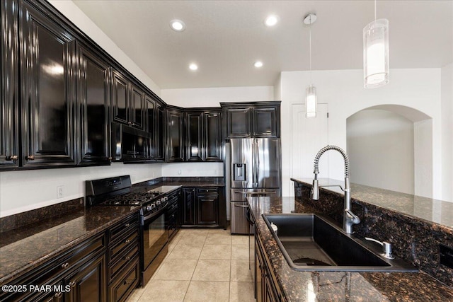 kitchen featuring dark stone countertops, sink, pendant lighting, and black appliances