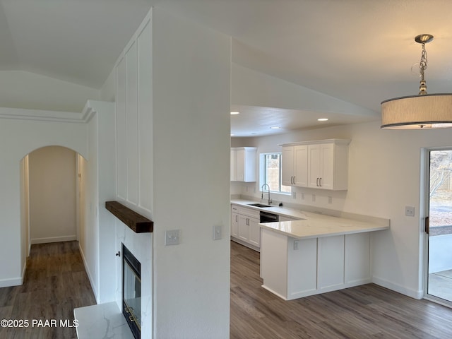 kitchen with lofted ceiling, dark wood-type flooring, hanging light fixtures, white cabinets, and kitchen peninsula