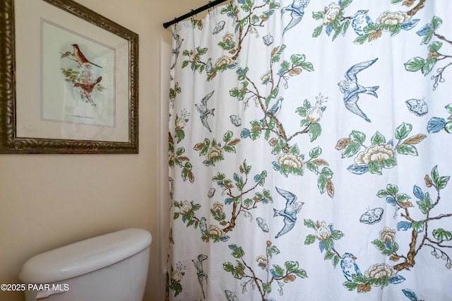 bathroom featuring a shower with shower curtain and toilet