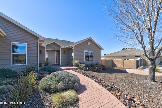 ranch-style home featuring fence