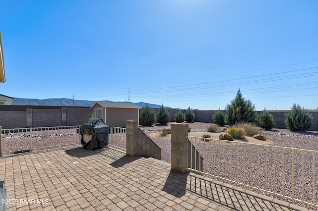 view of patio / terrace featuring a storage shed, an outbuilding, and a fenced backyard