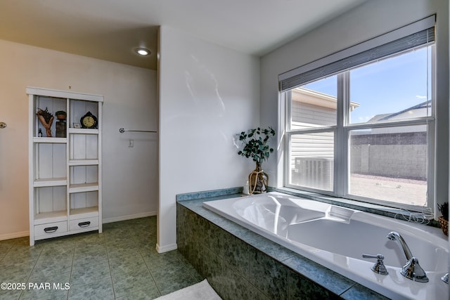 full bathroom with tile patterned floors, baseboards, and a garden tub