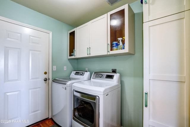 washroom featuring cabinet space and separate washer and dryer