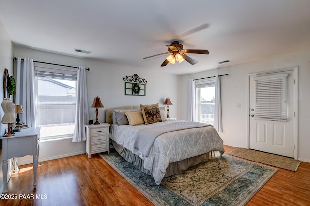 bedroom featuring multiple windows, wood finished floors, and visible vents